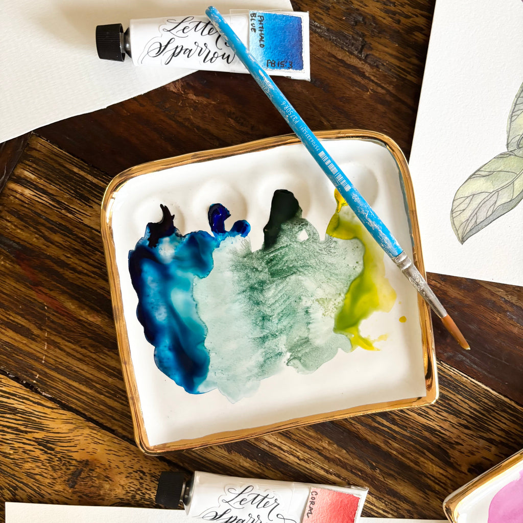 Another overhead view of "The Kris Palette". The palette is shown with cool-toned paints in use.
