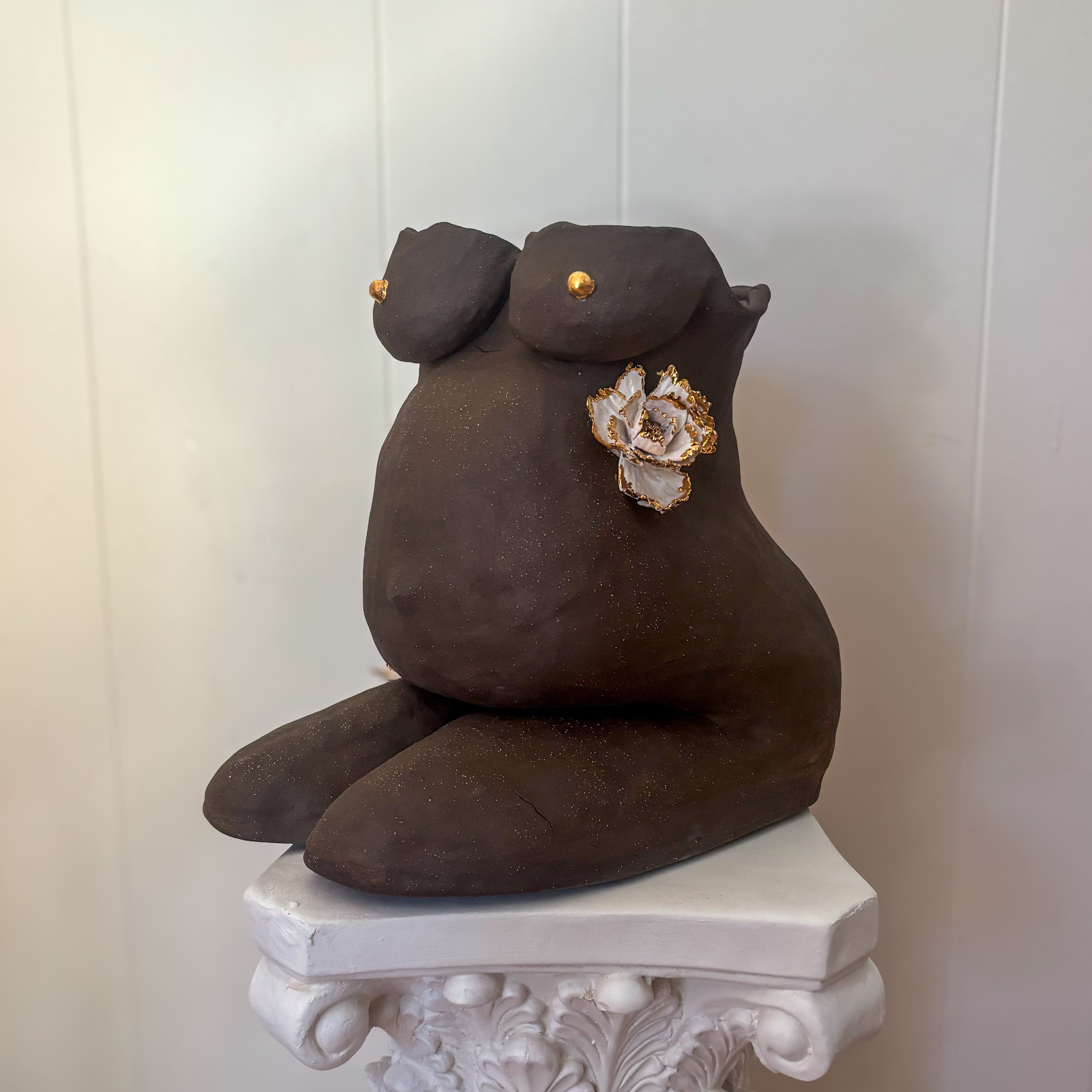A 45º-angle view featuring the left side of the sculpture "She Who Carries".