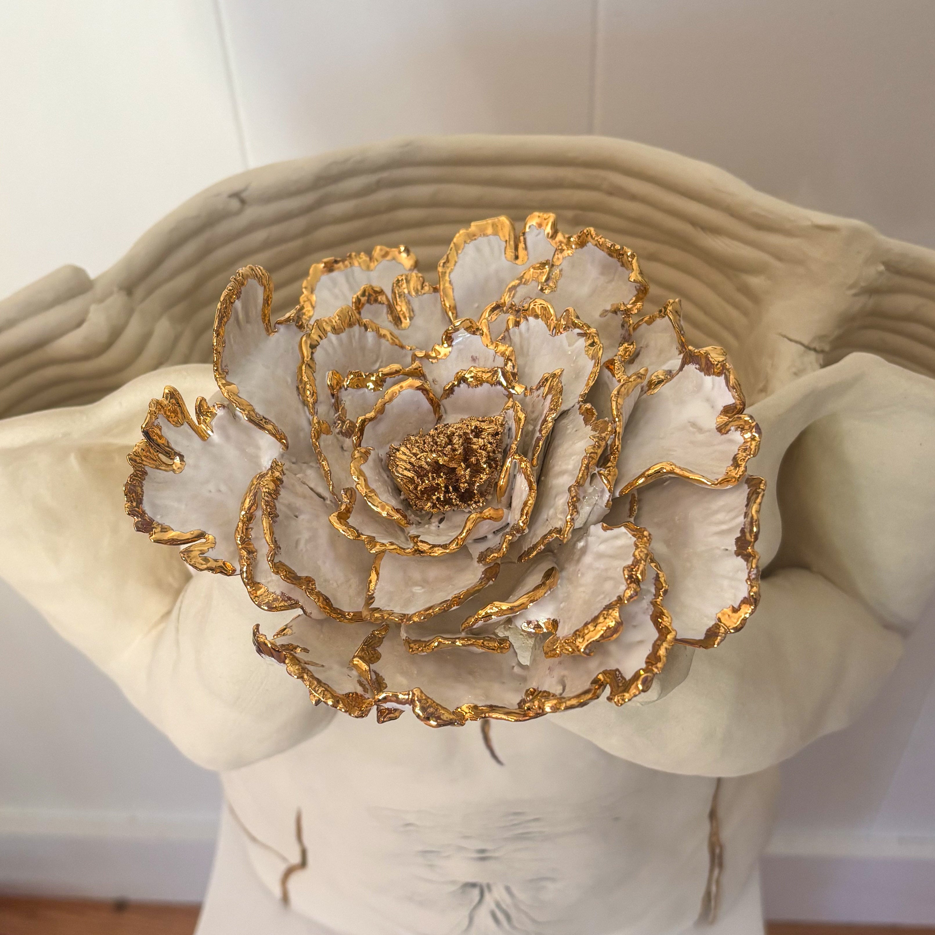 A close-up view of the 22k gold trimmed floral detail of the sculpture "She Who Holds".