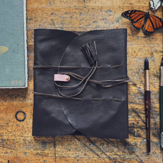 An overhead view of a hand-crafted, high-quality leather painter's palette "Mary Leather" wrap.