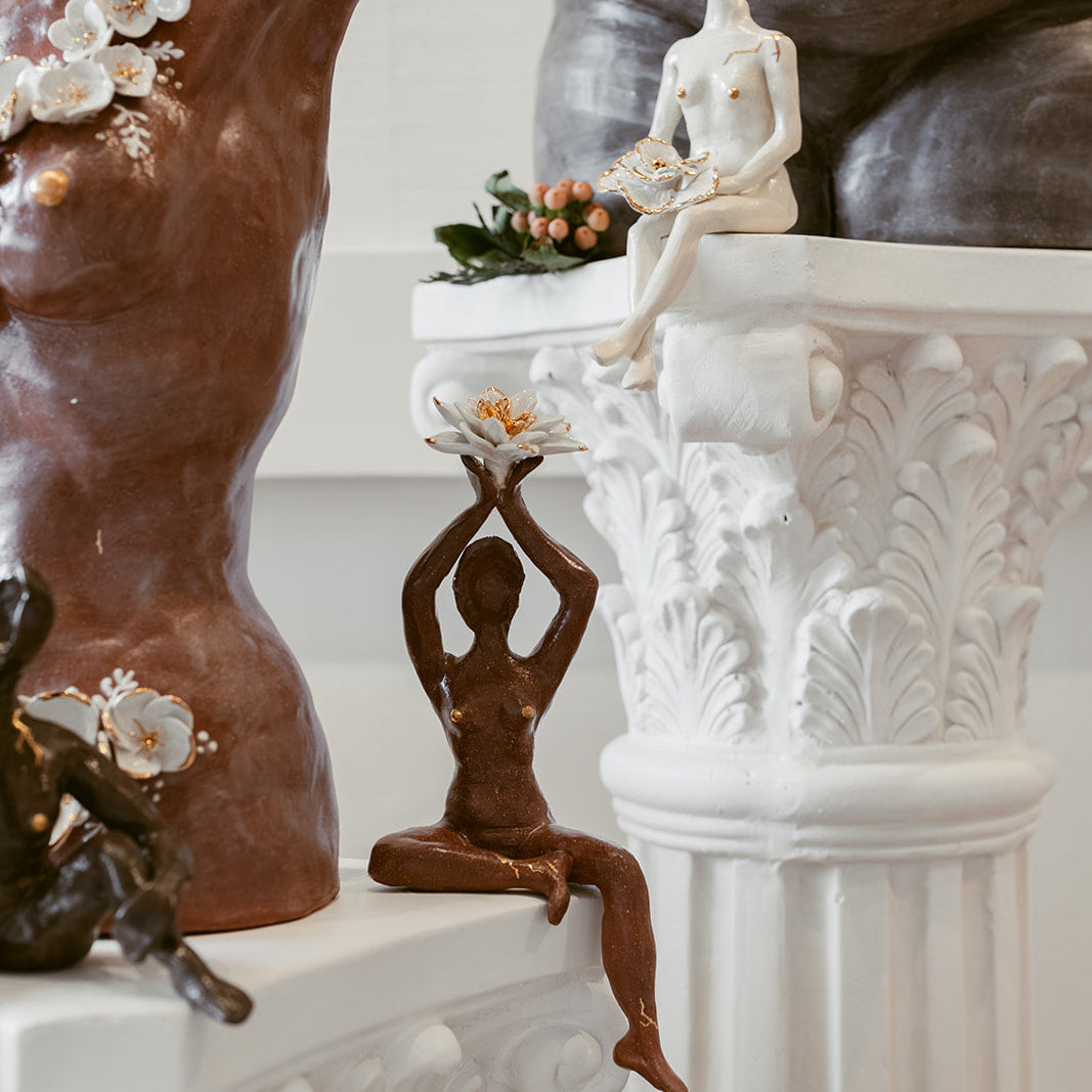 A close-up of the terracotta figurine of the piece, "She Who Gathers".