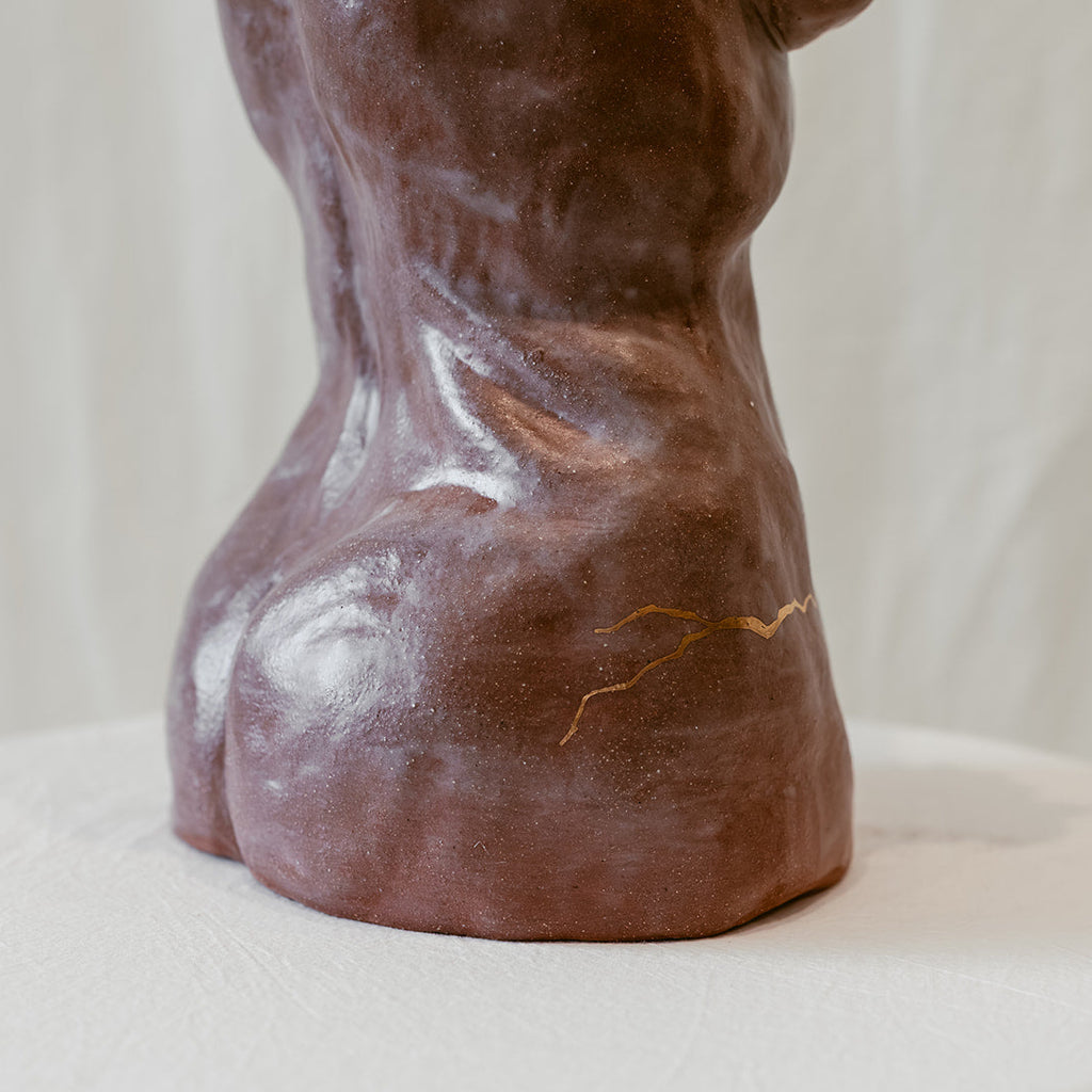 A close-up view of the bottom right of "She Who Remains" featuring one of the gold accented intentional cracks.