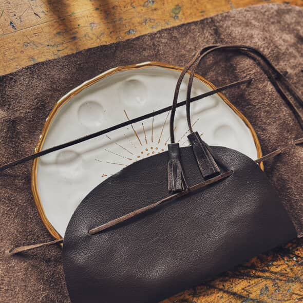 An angled overhead view of the "Mary Leather Wrap". The wrap is shown with a painter's palette encased.