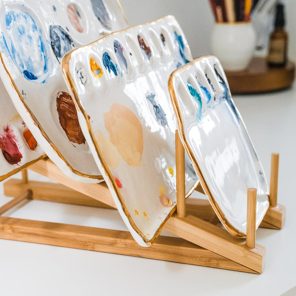 Another side angle view of a bamboo palette rack displayed with 4 painters palettes.