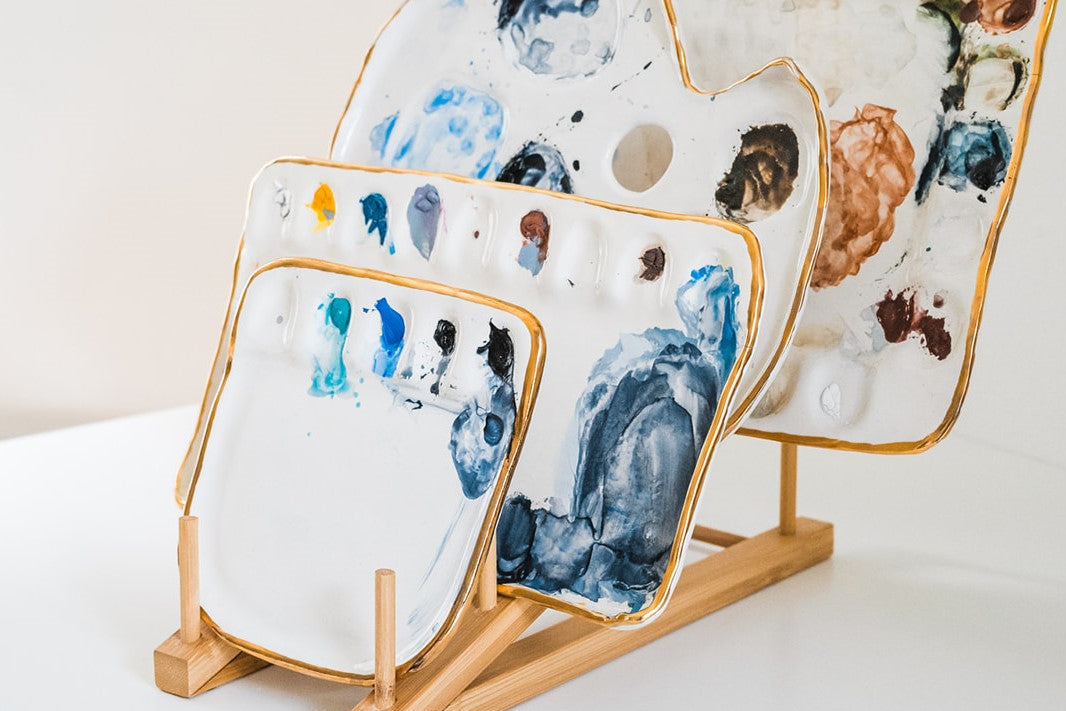 Another side angle view of a bamboo palette rack displayed with 4 painters palettes.