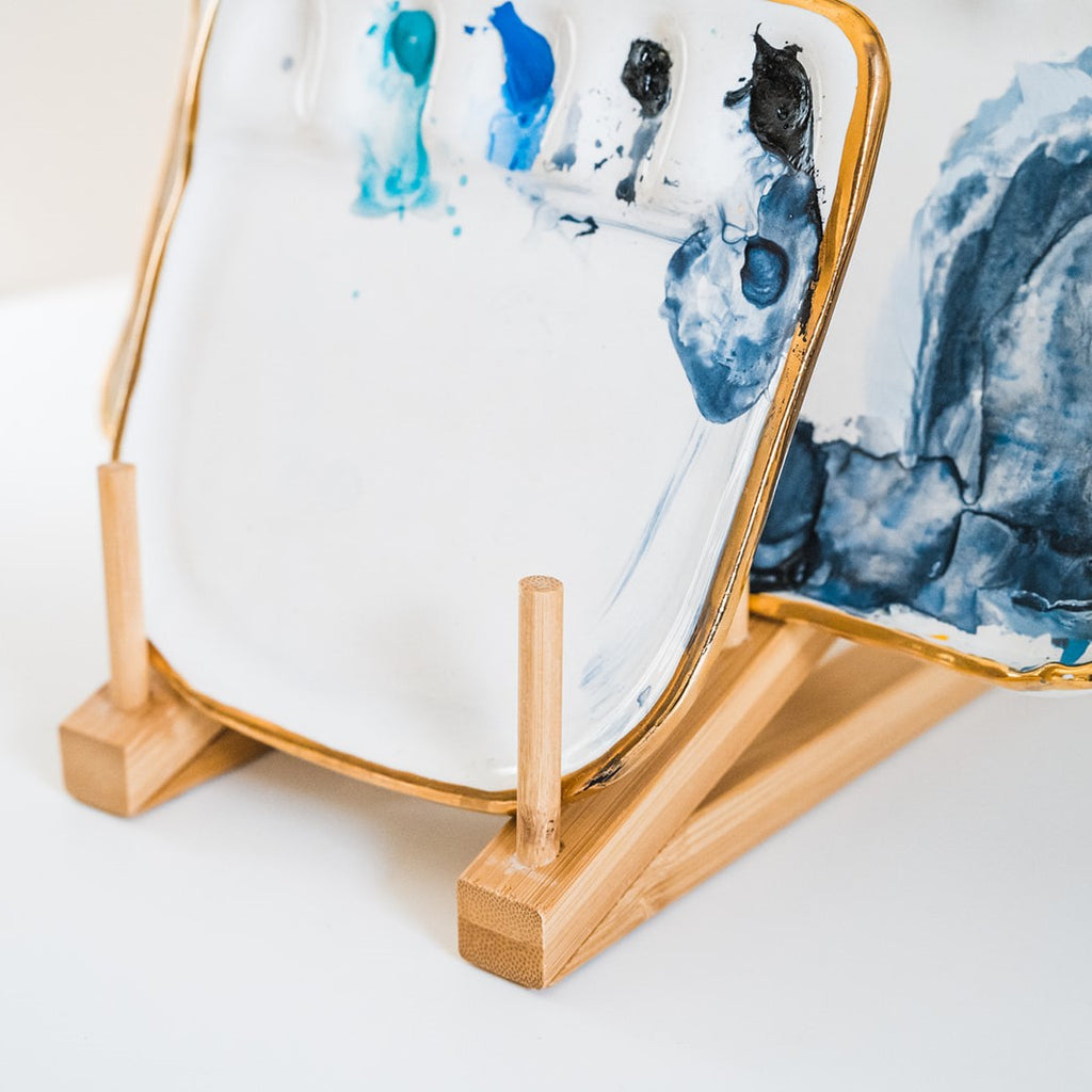 A close up 45º side angle view of a bamboo palette rack displayed with painter's palettes.