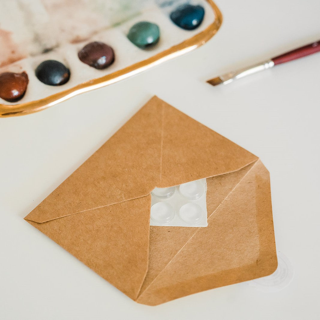 Another overhead view of a brown paper envelope with a four count of rubber pottery feet enclosed.