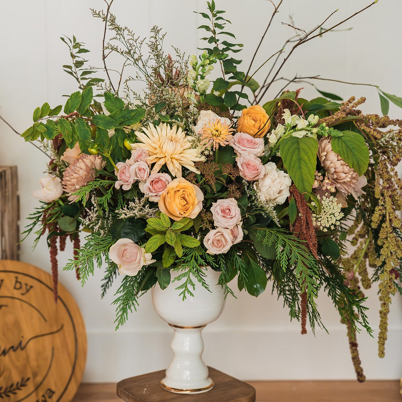 Floral arrangement full of yellow flowers in the compote vase